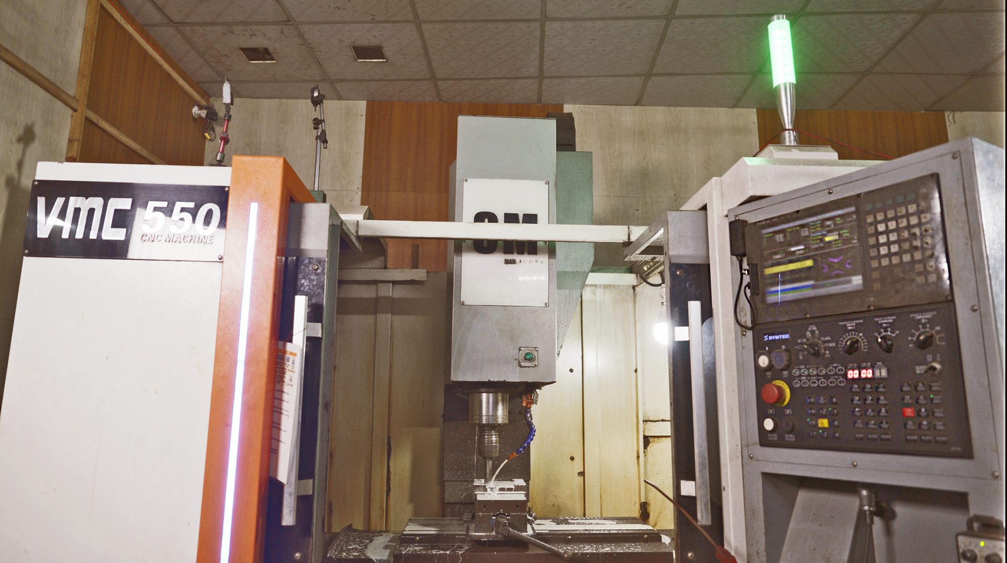 A CNC machine processes metal components at a machinery and equipment microenterprise.