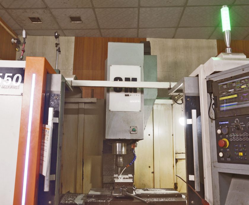 A CNC machine processes metal components at a machinery and equipment microenterprise.